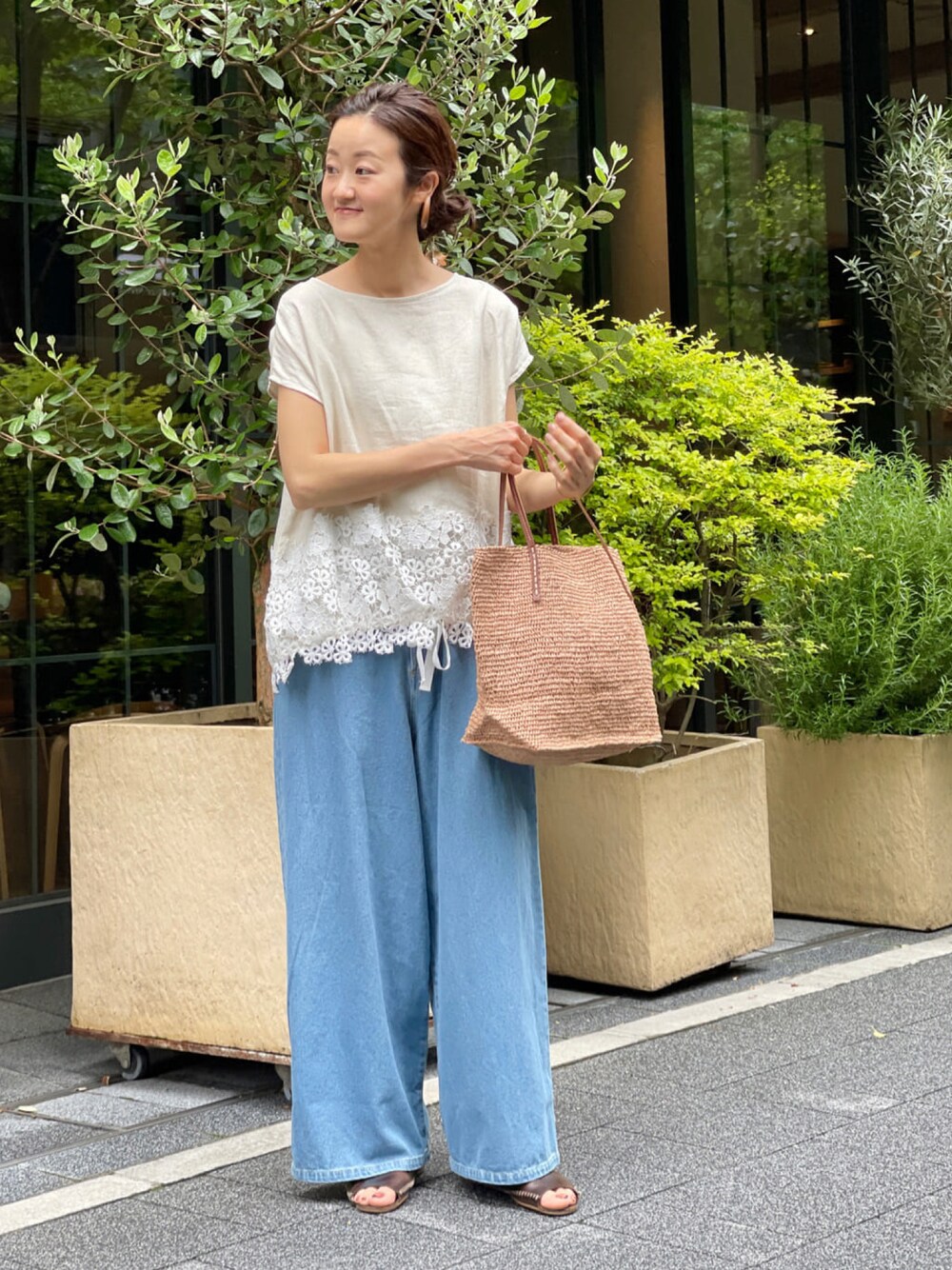 ベージュ系のシャツ/ブラウス、ブルー系のデニムパンツ、ベージュ系のかごバッグを着用したレディースの春コーディネートの1枚目の写真