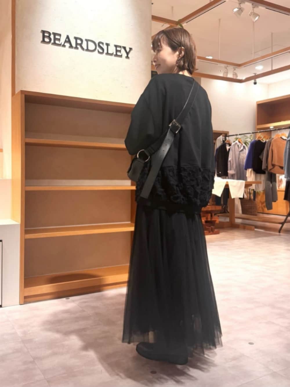 ブラック系のTシャツ/カットソー、ブラック系のスカートを着用したレディースの秋コーディネートの1枚目の写真