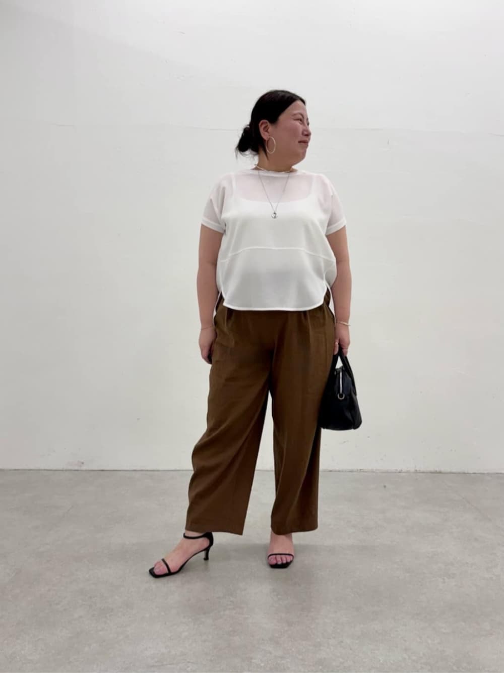 ブラック系のボストンバッグ、ホワイト系のシャツ/ブラウス、ブラウン系のその他パンツを着用したレディースの春コーディネートの1枚目の写真