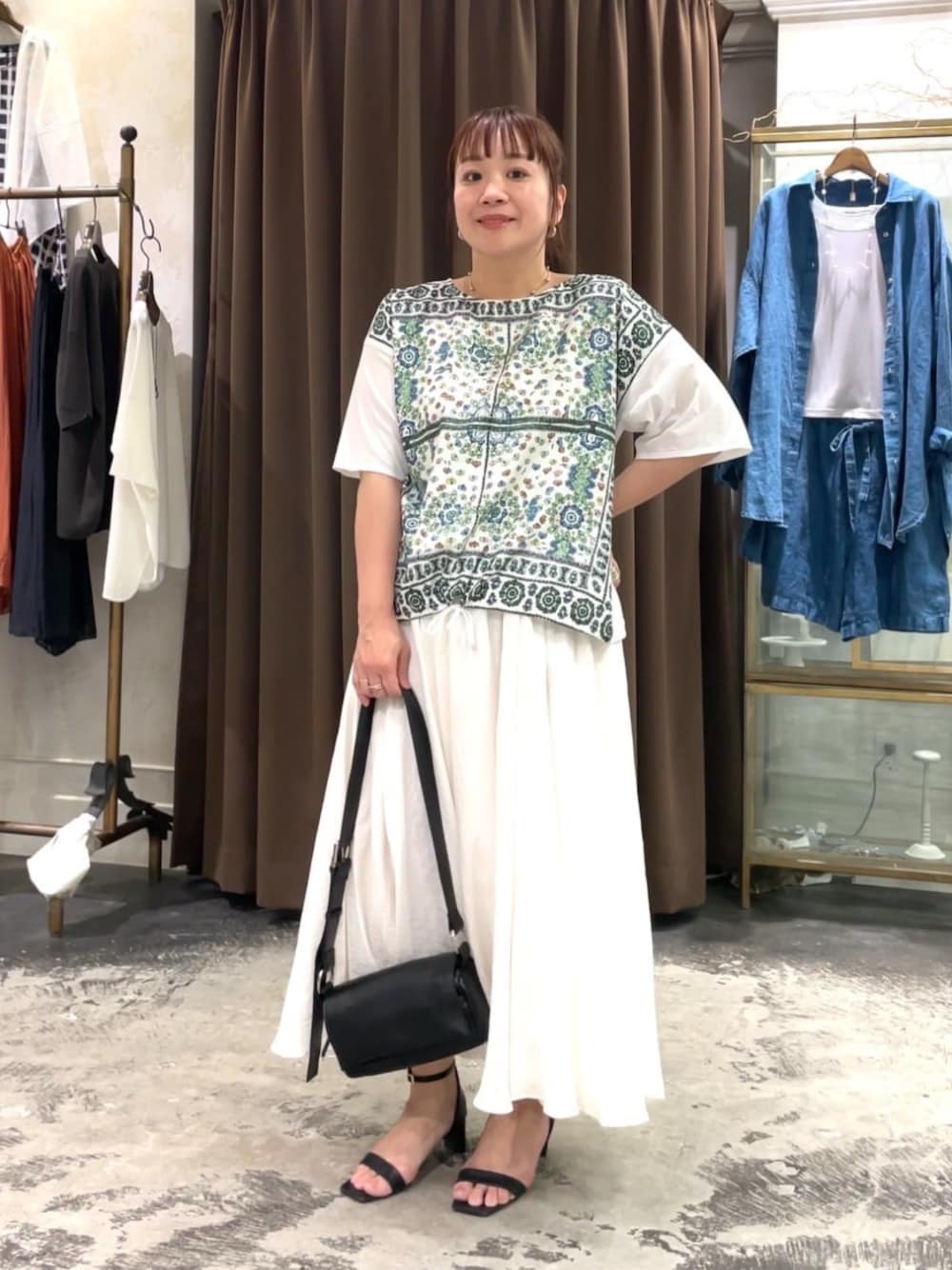 ホワイト系のスカート、ホワイト系のTシャツ/カットソーを着用したレディースの春コーディネートの1枚目の写真