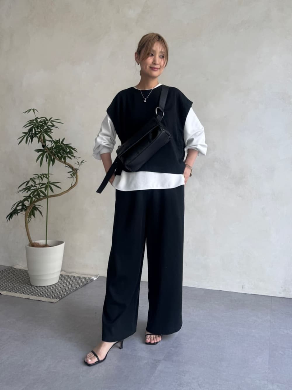 ブルー系のベスト、ブルー系のその他パンツ、ブラック系のショルダーバッグを着用したレディースの夏コーディネートの1枚目の写真