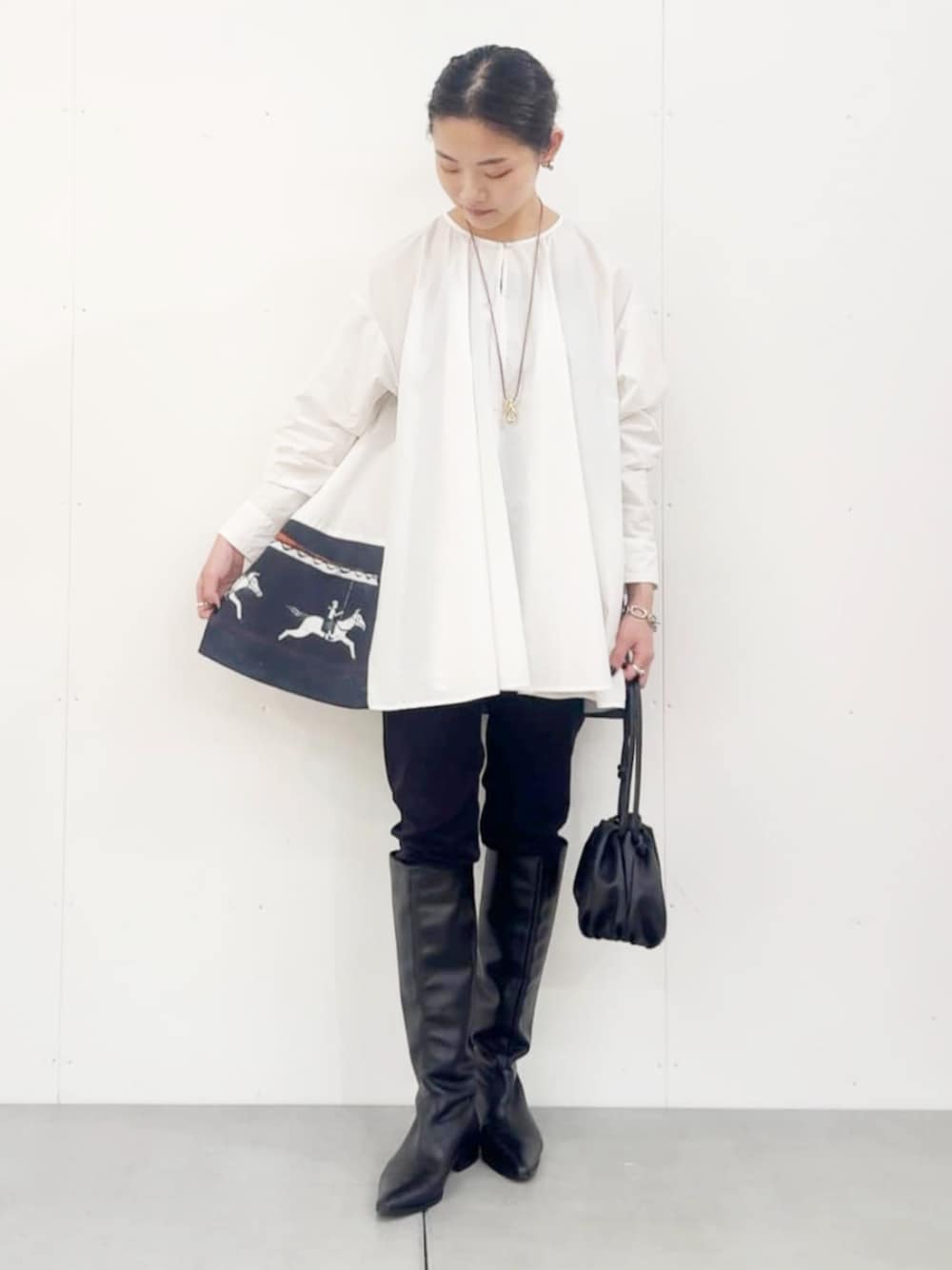 ブラック系のショルダーバッグ、ホワイト系のシャツ/ブラウス、ブラック系のその他パンツを着用したレディースの秋コーディネートの1枚目の写真