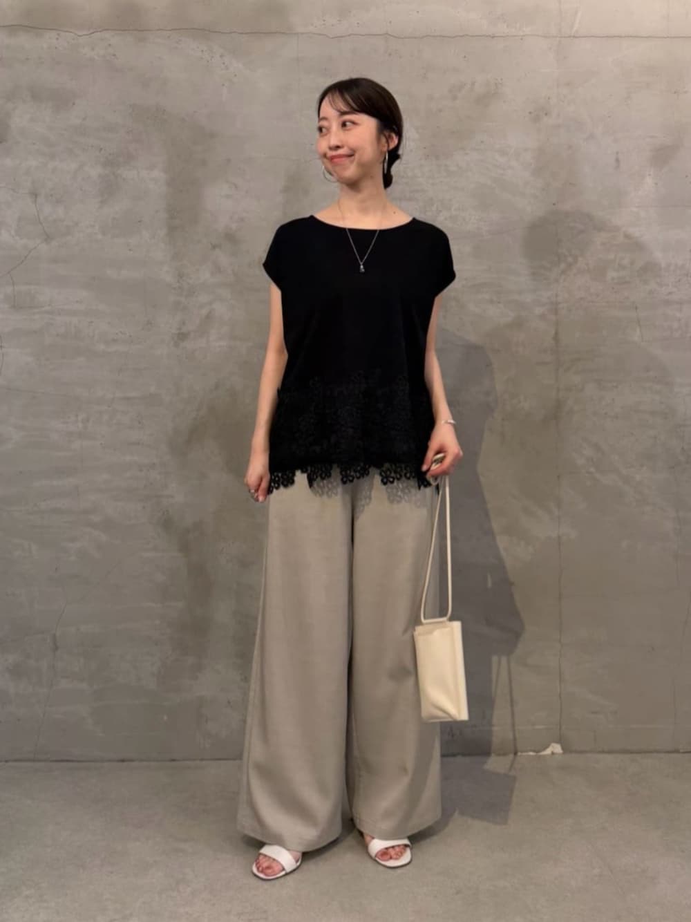 ホワイト系のショルダーバッグ、グレー系のその他パンツ、ブラック系のTシャツ/カットソーを着用したレディースの春コーディネートの1枚目の写真
