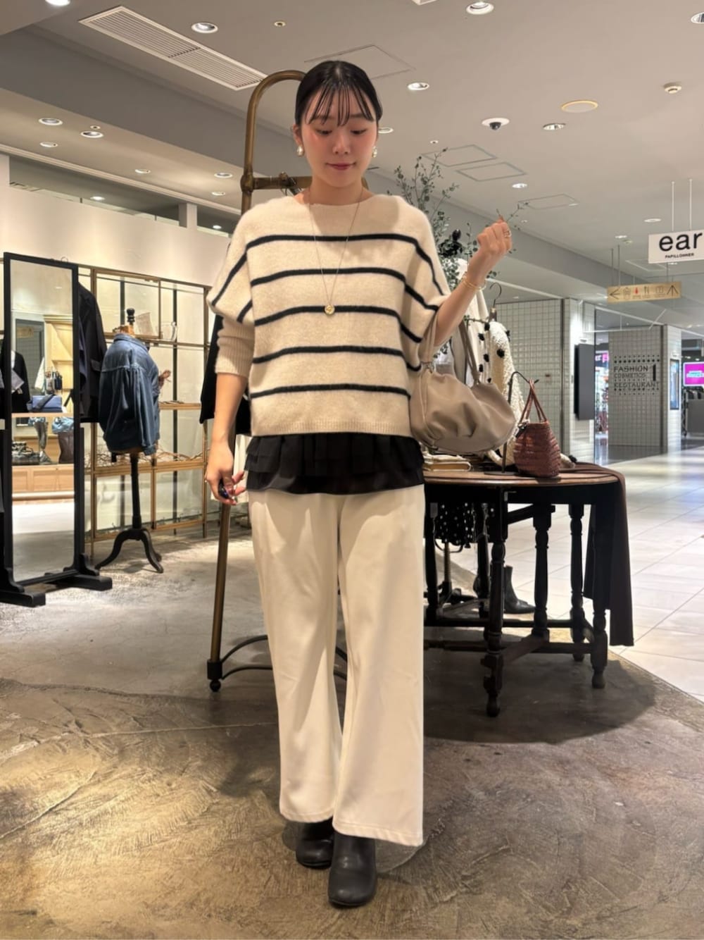 ベージュ系のショルダーバッグ、ホワイト系のニット/セーター、ホワイト系のその他パンツを着用したレディースの冬コーディネートの1枚目の写真