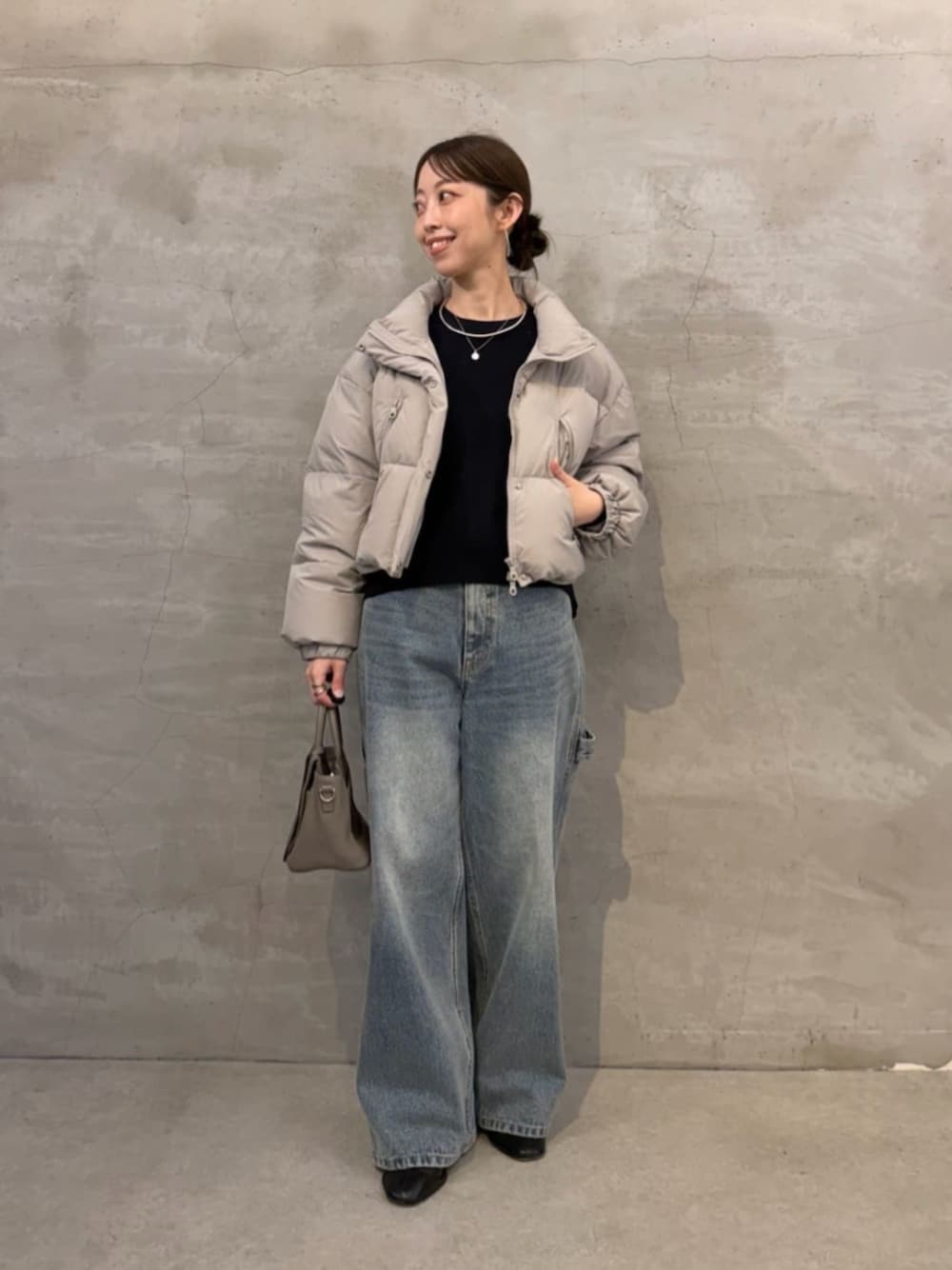 ブルー系のニット/セーター、ブルー系のデニムパンツ、グレー系のダウンジャケット/コートを着用したレディースの秋コーディネートの1枚目の写真