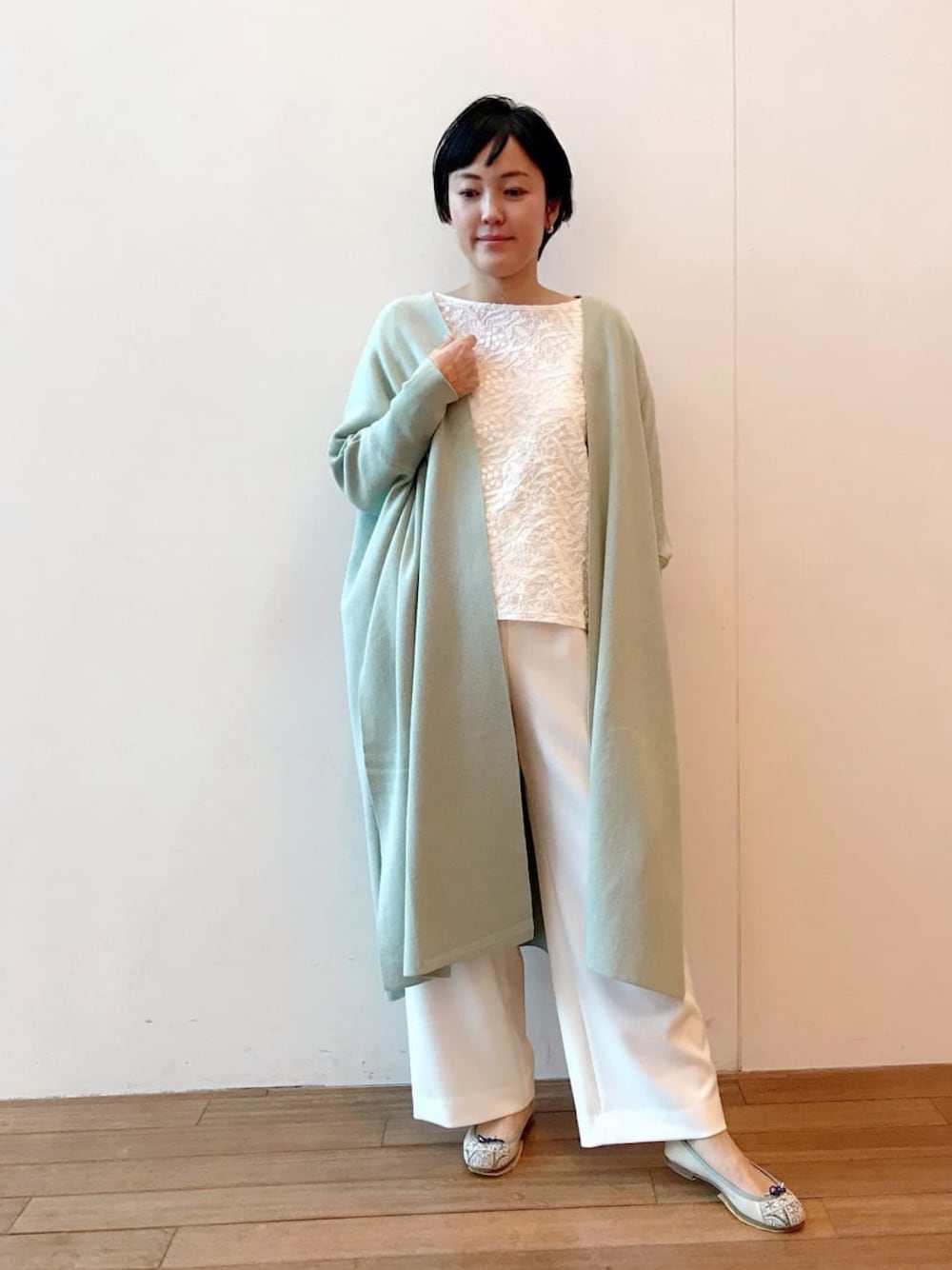 グリーン系のカーディガン/ボレロ、ホワイト系のTシャツ/カットソーを着用したレディースの冬コーディネートの1枚目の写真