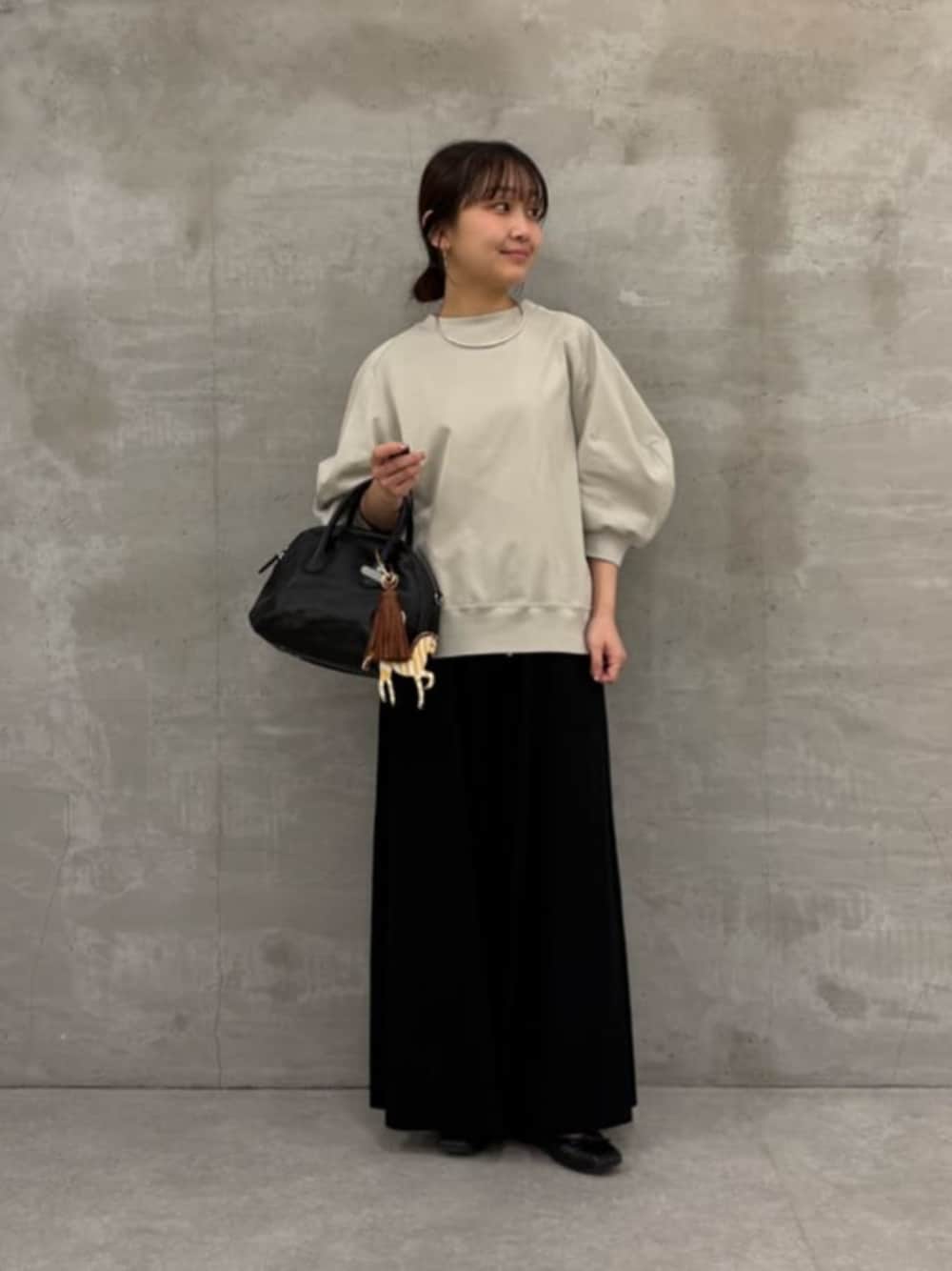 ブラック系のボストンバッグ、ブラック系のその他パンツ、グレー系のTシャツ/カットソーを着用したレディースの冬コーディネートの1枚目の写真