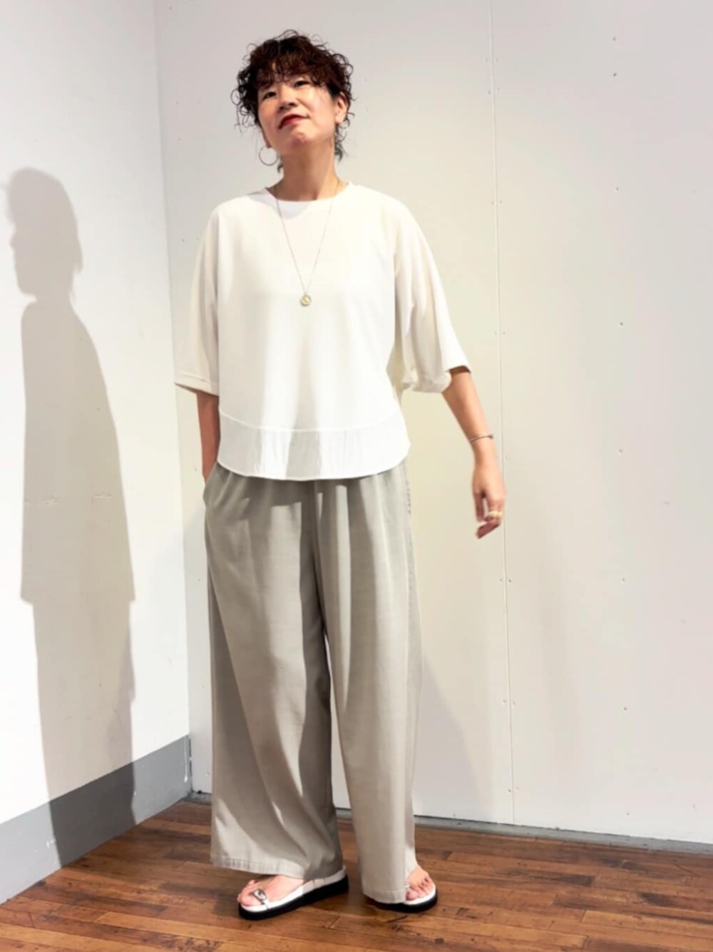 グレー系のその他パンツ、ホワイト系のTシャツ/カットソーを着用したレディースの春コーディネートの1枚目の写真