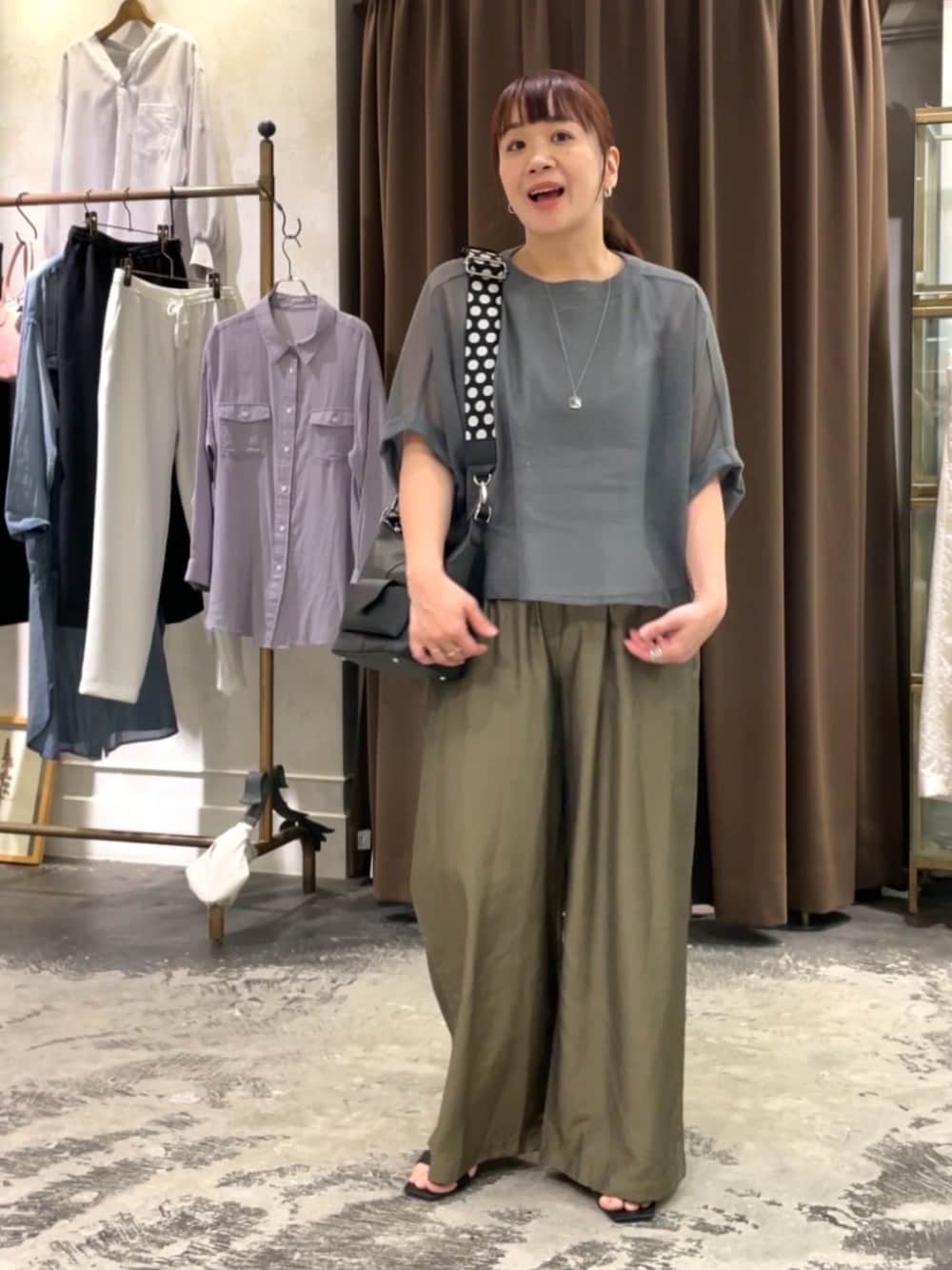 ブラック系のトートバッグ、グレー系のTシャツ/カットソー、グリーン系のその他パンツを着用したレディースの春コーディネートの1枚目の写真