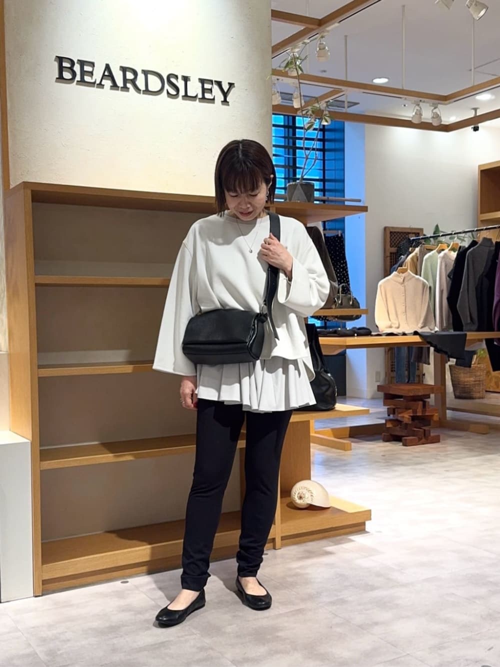 ブラック系のその他パンツ、ブラック系のショルダーバッグ、ホワイト系のTシャツ/カットソーを着用したレディースの冬コーディネートの1枚目の写真