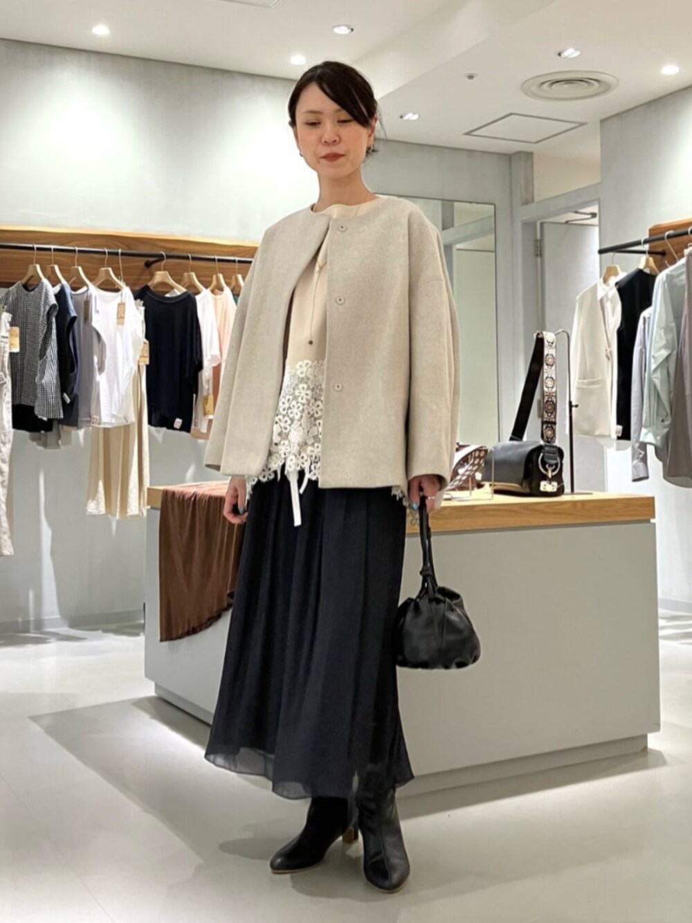 ブラック系のショルダーバッグ、ブラック系のその他パンツ、グレー系のノーカラーコートを着用したレディースの秋コーディネートの1枚目の写真