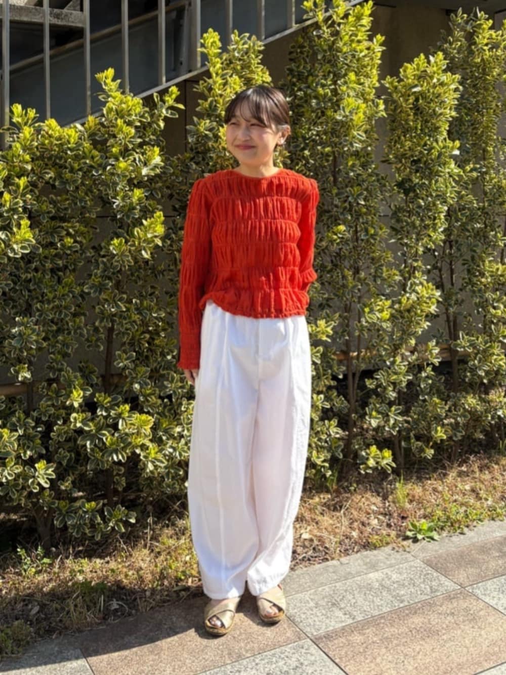 オレンジ系のシャツ/ブラウス、ホワイト系のその他パンツを着用したレディースの春コーディネートの1枚目の写真