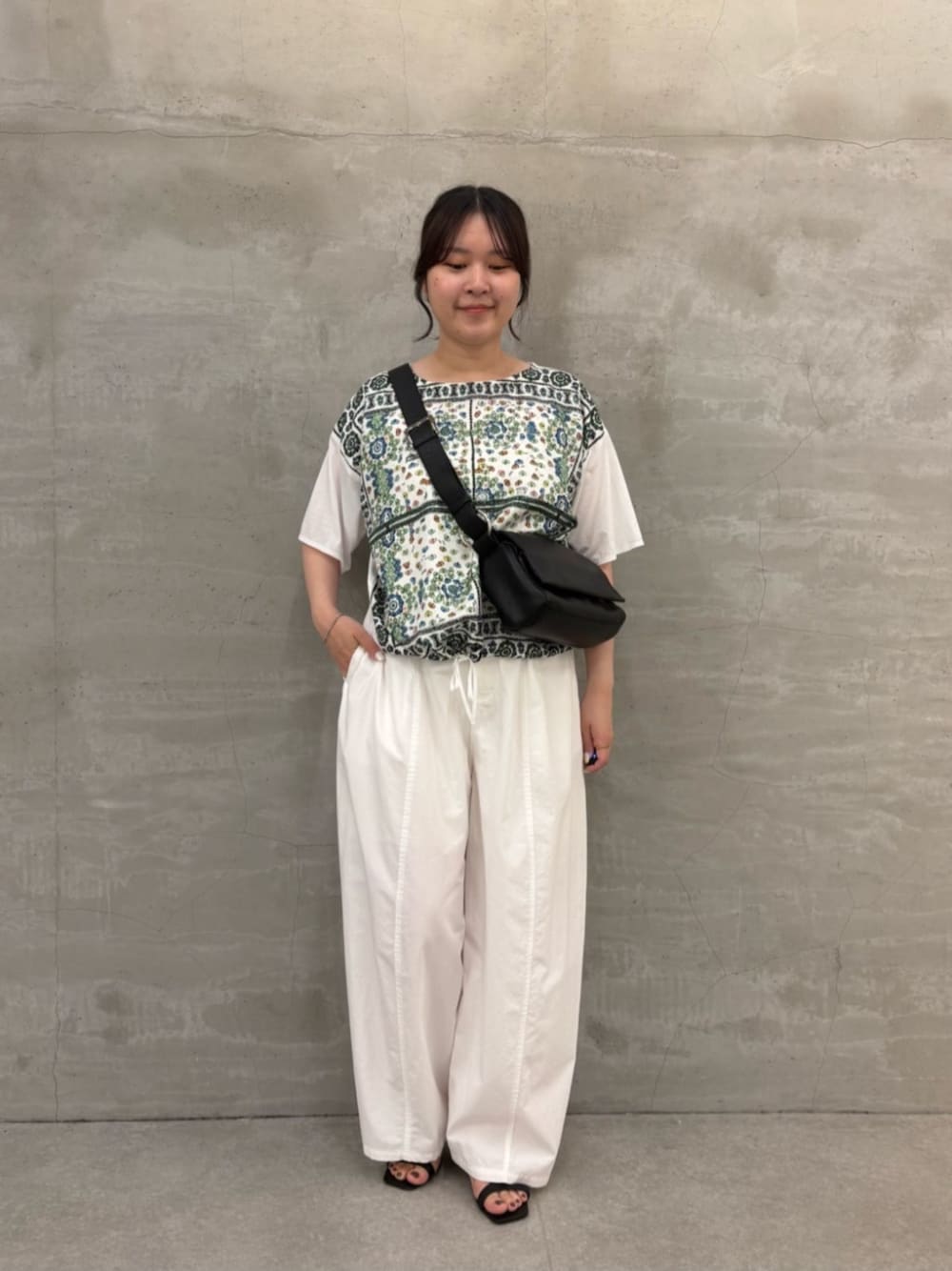 ブラック系のショルダーバッグ、ホワイト系のTシャツ/カットソーを着用したレディースの春コーディネートの1枚目の写真