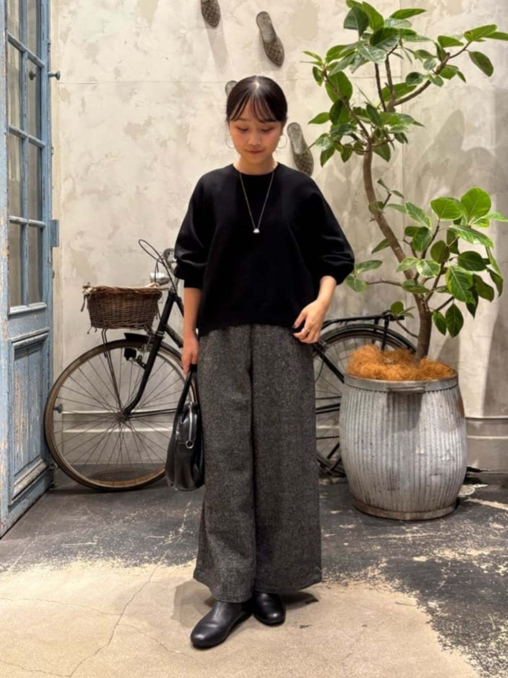 ブラック系のニット/セーター、グレー系のその他パンツを着用したレディースの夏コーディネートの1枚目の写真