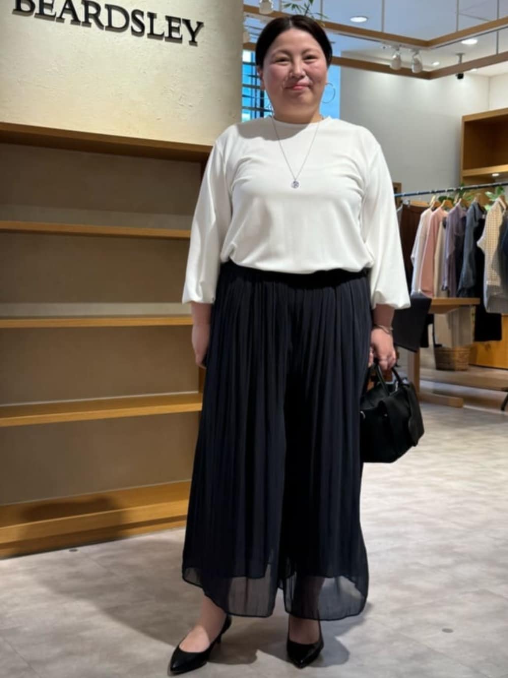 ブラック系のハンドバッグ、ホワイト系のシャツ/ブラウス、ブラック系のその他パンツを着用したレディースの春コーディネートの1枚目の写真