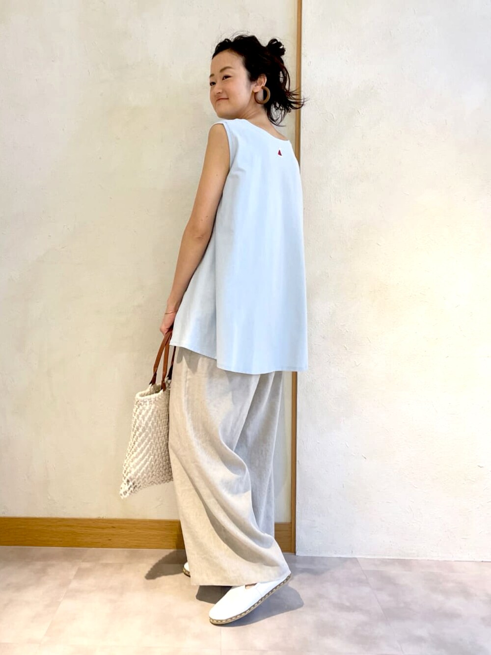 ブルー系のTシャツ/カットソー、ベージュ系のその他パンツ、ベージュ系のトートバッグを着用したレディースの春コーディネートの1枚目の写真