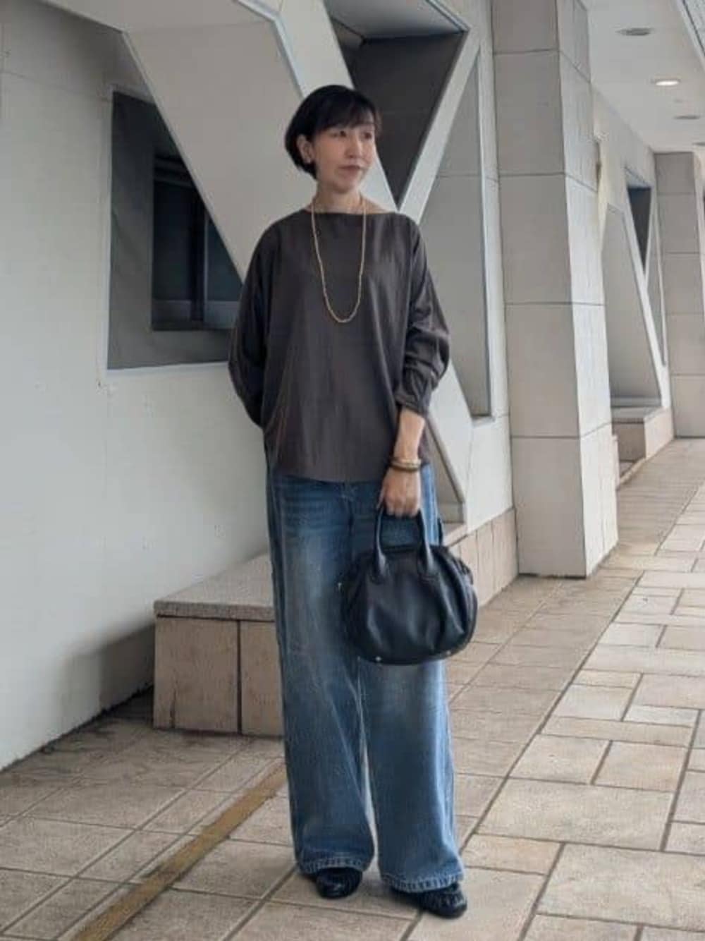 ブラック系のボストンバッグ、ブルー系のその他パンツ、ブラウン系のTシャツ/カットソーを着用したレディースの夏コーディネートの1枚目の写真