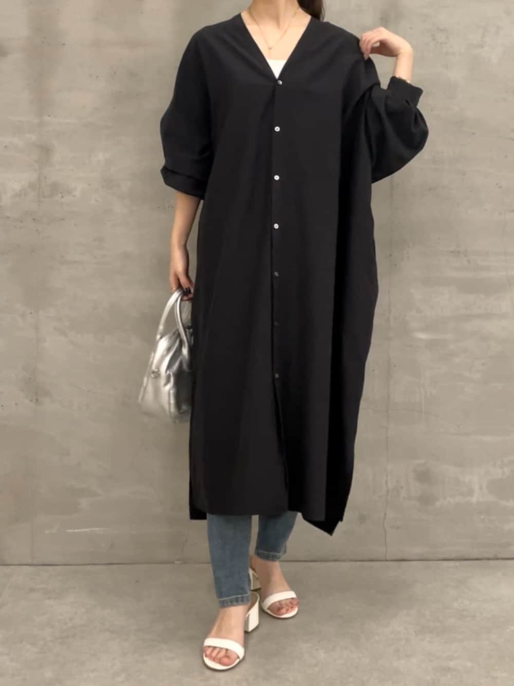 ブルー系のデニムパンツ、ブラック系のワンピースを着用したレディースの冬コーディネートの1枚目の写真