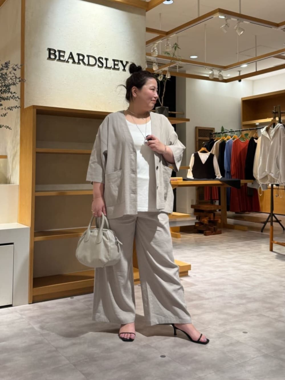 グレー系のボストンバッグ、ホワイト系のシャツ/ブラウス、グレー系のその他パンツを着用したレディースの春コーディネートの1枚目の写真