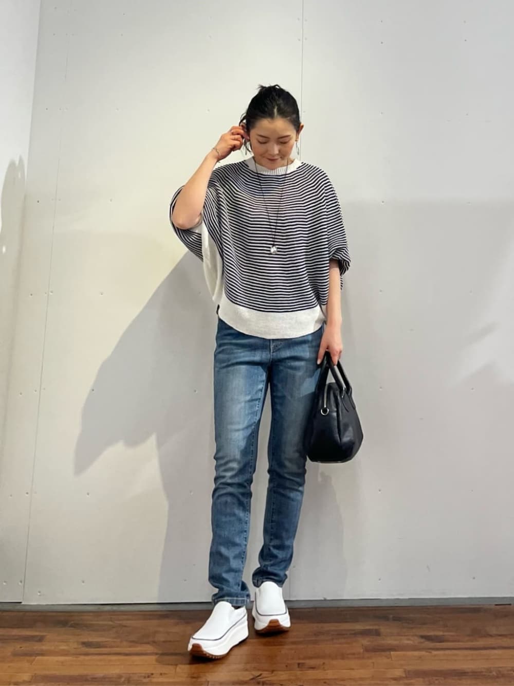 ブルー系のデニムパンツ、ブルー系のニット/セーターを着用したレディースの春コーディネートの1枚目の写真