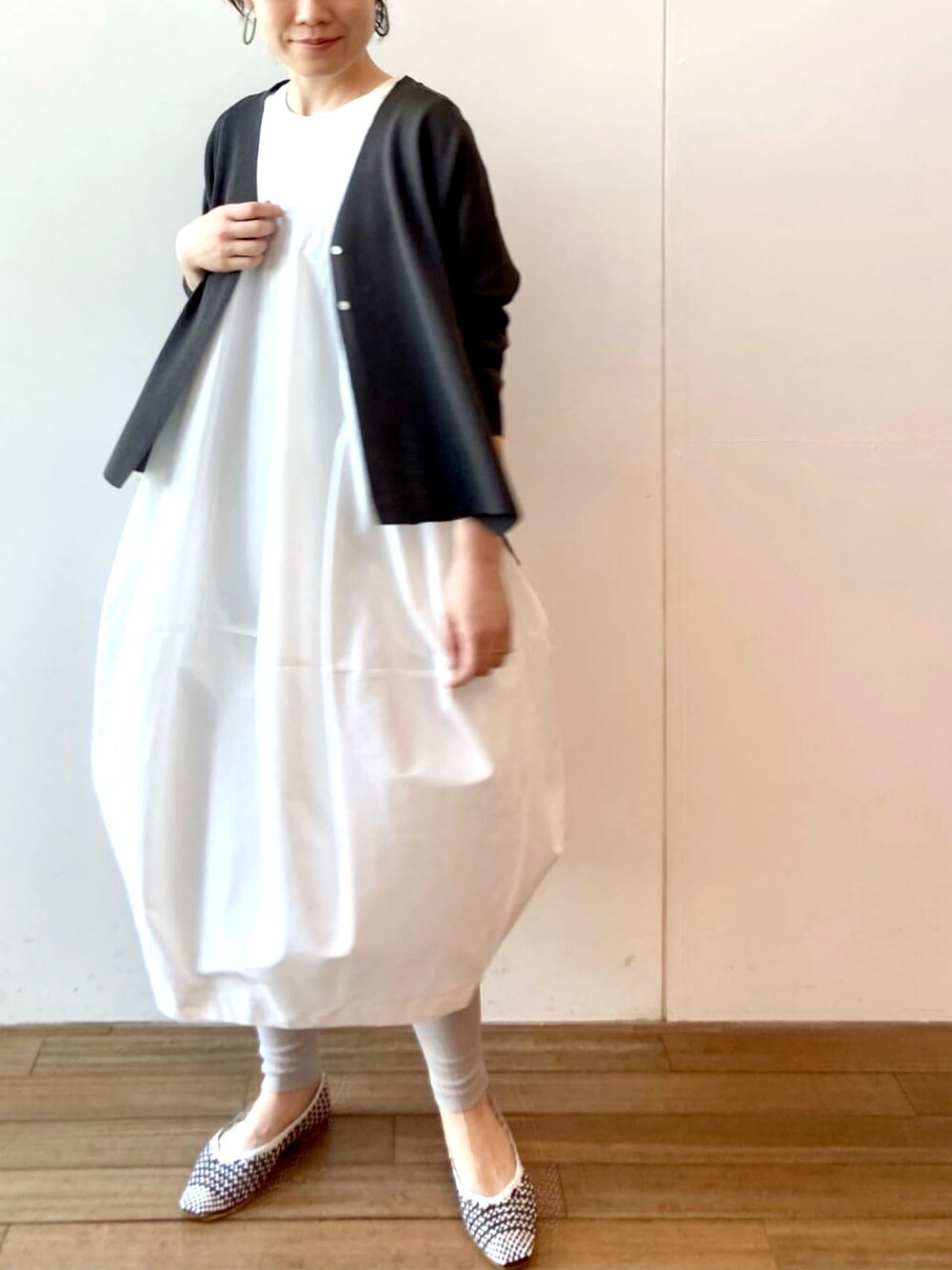 ホワイト系のワンピース、ブラック系のカーディガン/ボレロ、グレー系のその他パンツを着用したレディースの春コーディネートの1枚目の写真