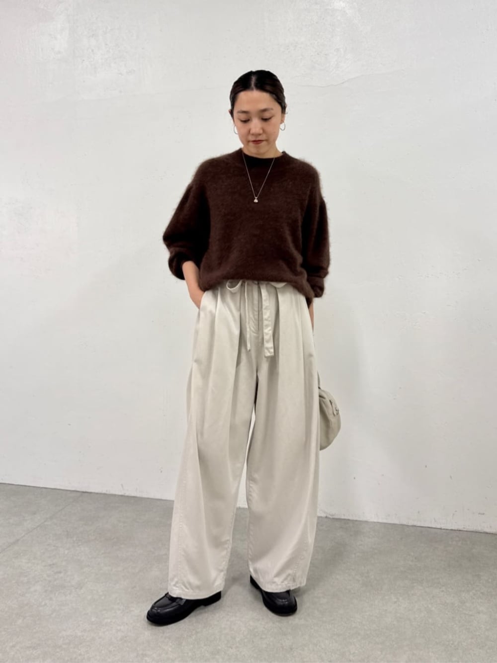 ブラック系のローファー、ホワイト系のその他パンツ、ブラウン系のニット/セーターを着用したレディースの秋コーディネートの1枚目の写真