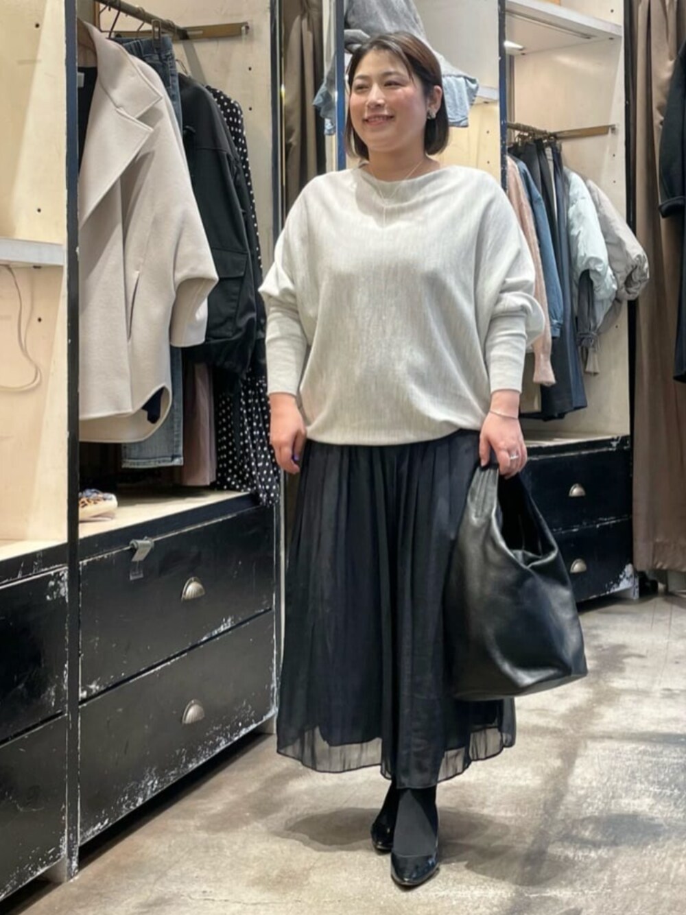 ブラック系のその他パンツ、グレー系のニット/セーター、ブラック系のトートバッグを着用したレディースの冬コーディネートの1枚目の写真
