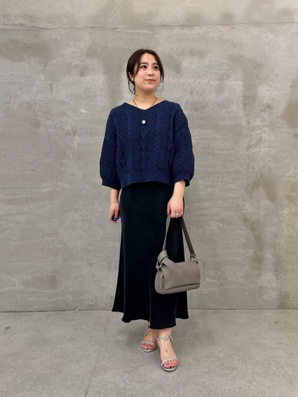 グレー系のショルダーバッグ、ブルー系のニット/セーターを着用したレディースの冬コーディネートの1枚目の写真