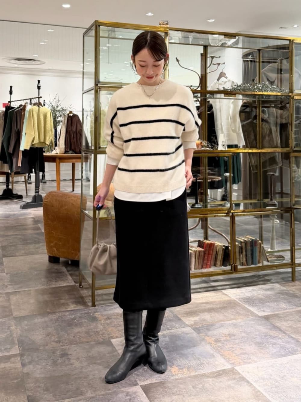 ベージュ系のショルダーバッグ、ホワイト系のシャツ/ブラウス、ブラック系のスカートを着用したレディースの冬コーディネートの1枚目の写真