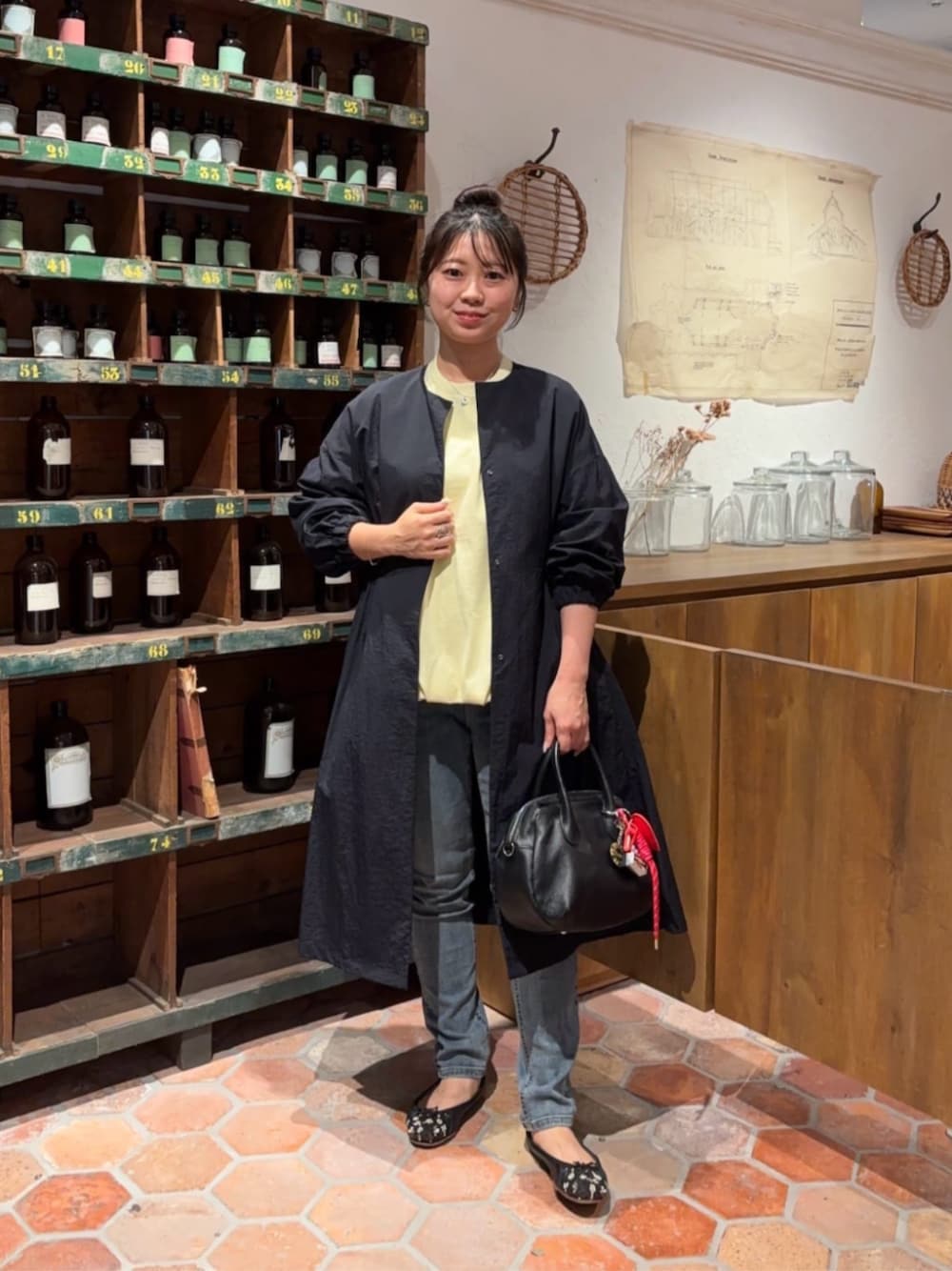 ブルー系のデニムパンツ、ブラック系のボストンバッグ、イエロー系のTシャツ/カットソーを着用したレディースの冬コーディネートの1枚目の写真