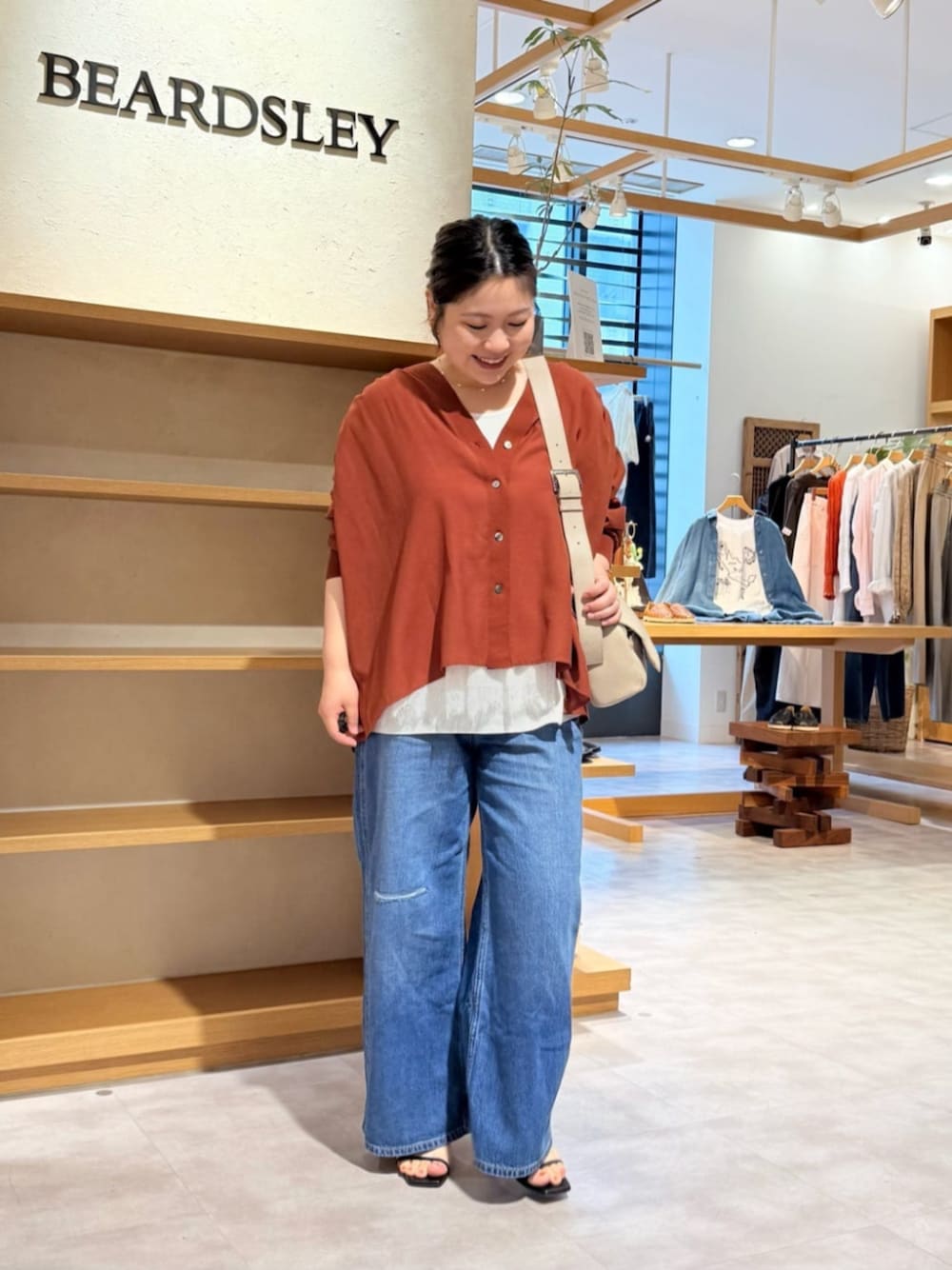 ベージュ系のショルダーバッグ、ブルー系のその他パンツ、レッド系のシャツ/ブラウスを着用したレディースの春コーディネートの1枚目の写真