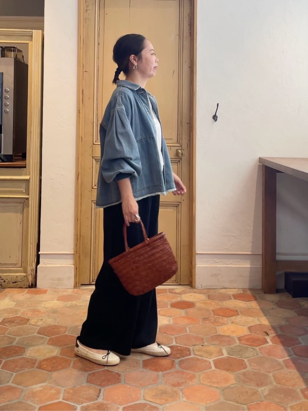 イエロー系のトートバッグを着用したレディースの冬コーディネートの1枚目の写真