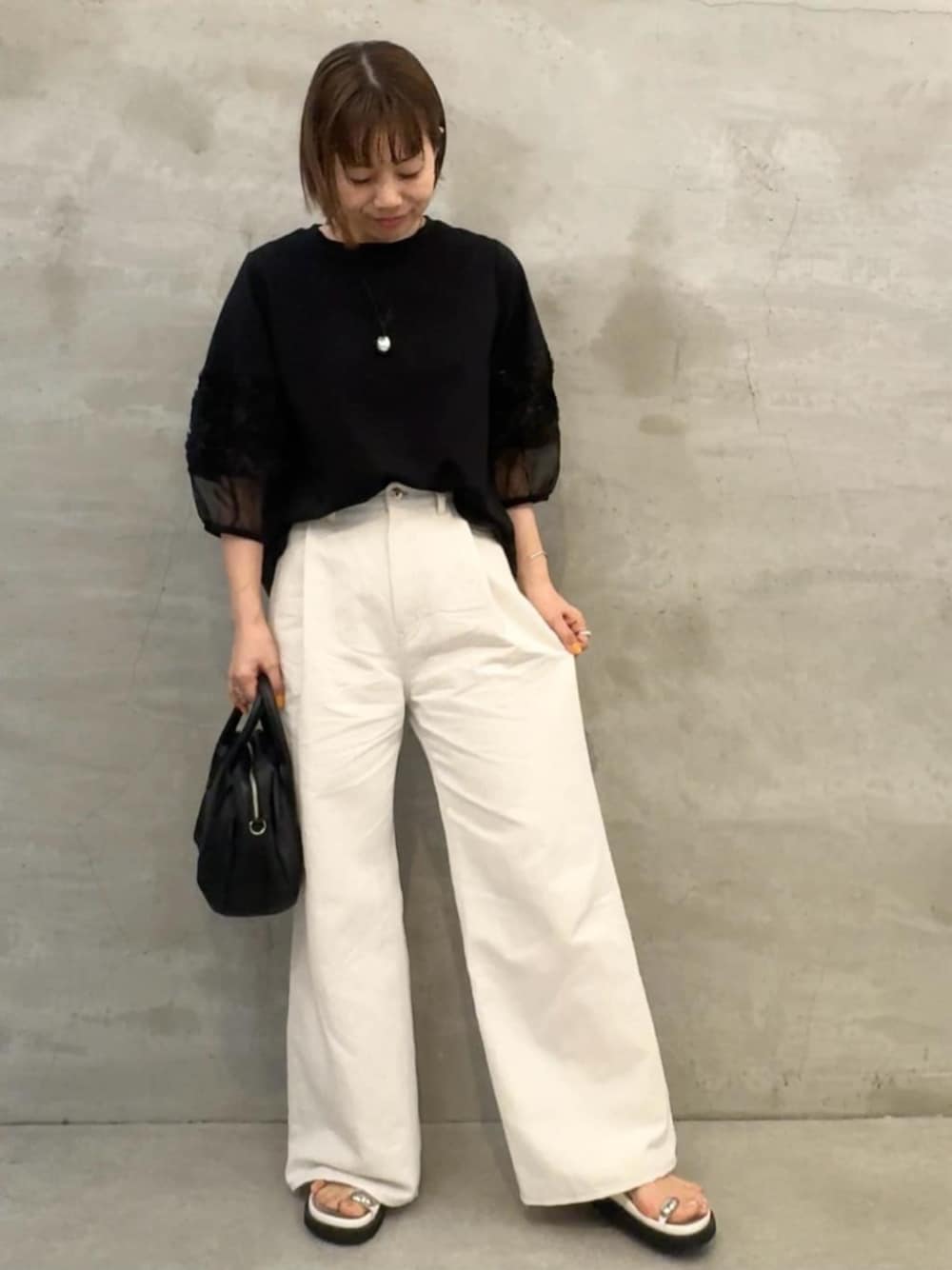 ブラック系のTシャツ/カットソー、ホワイト系のその他パンツを着用したレディースの春コーディネートの1枚目の写真