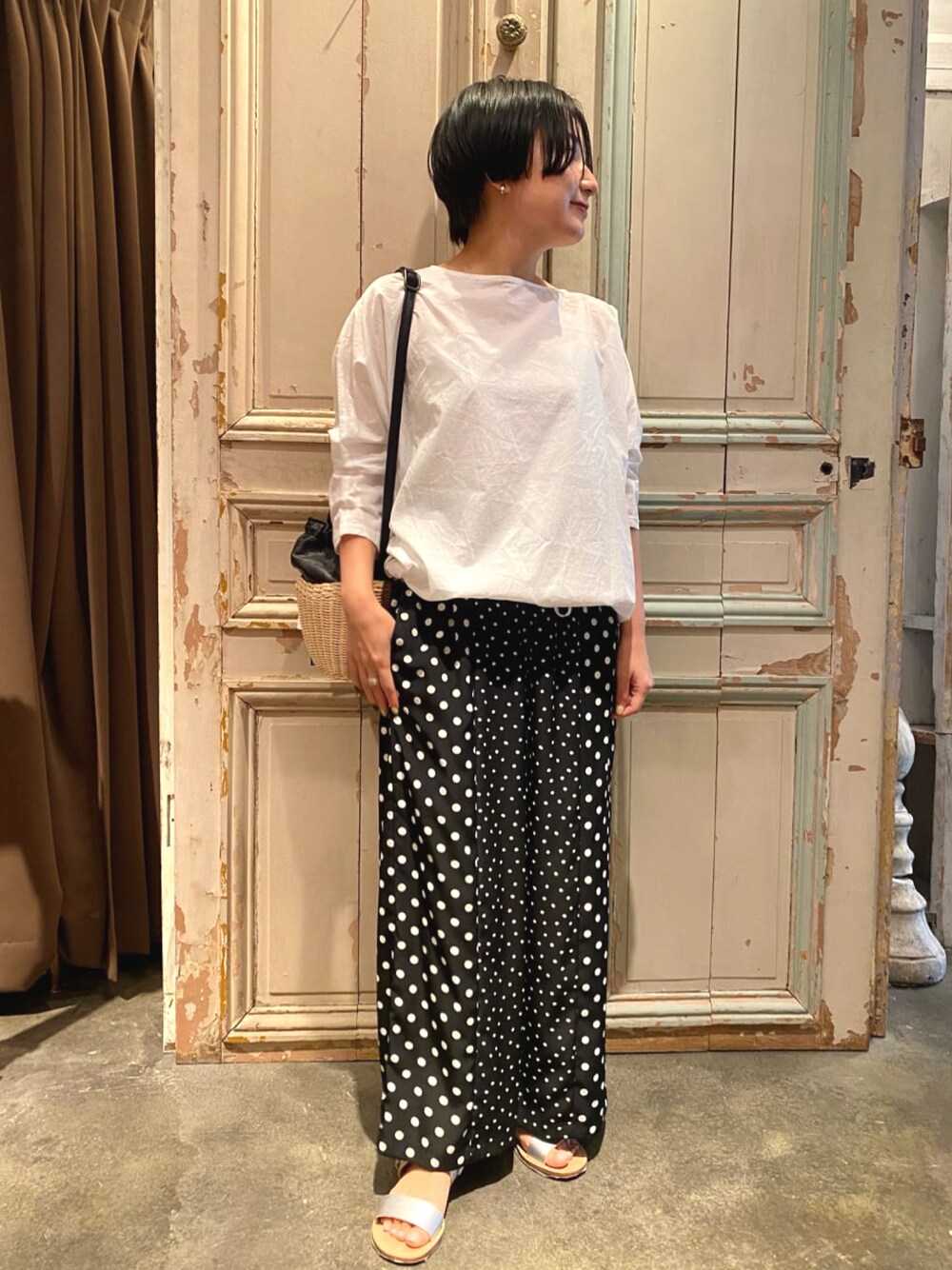 ブラック系のその他パンツ、ホワイト系のシャツ/ブラウス、シルバー系のサンダルを着用したレディースの春コーディネートの1枚目の写真