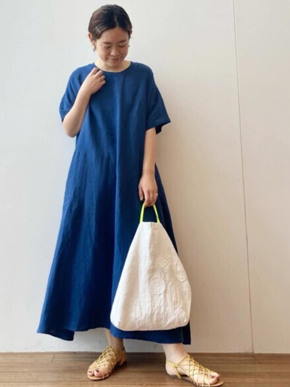 ブルー系のワンピース、ホワイト系のトートバッグを着用したレディースの夏コーディネートの1枚目の写真