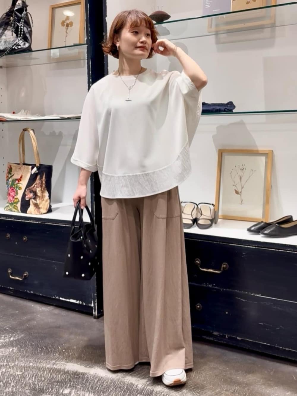ベージュ系のその他パンツ、ブラック系のトートバッグ、ホワイト系のTシャツ/カットソーを着用したレディースの春コーディネートの1枚目の写真