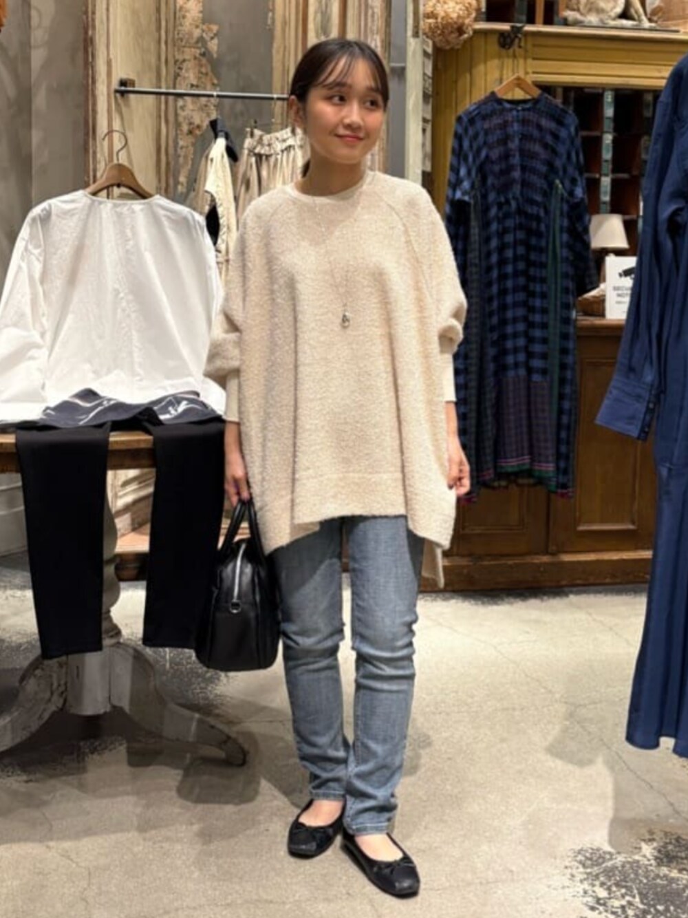 ブルー系のデニムパンツ、ホワイト系のニット/セーターを着用したレディースの秋コーディネートの1枚目の写真