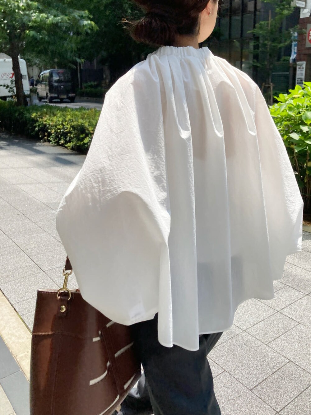 ホワイト系のシャツ/ブラウス、グレー系のその他パンツ、ブラウン系のトートバッグを着用したレディースの春コーディネートの1枚目の写真