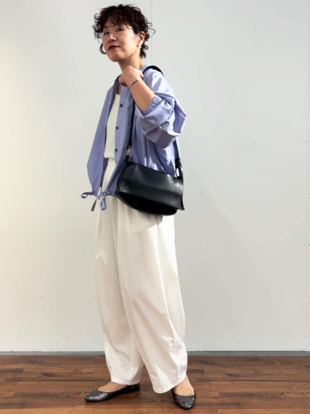 ホワイト系のタンクトップ、ブラック系のショルダーバッグ、ホワイト系のその他パンツを着用したレディースの冬コーディネートの1枚目の写真