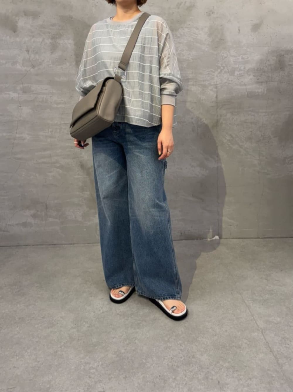 ブルー系のその他パンツ、ホワイト系のサンダル、グレー系のシャツ/ブラウスを着用したレディースの春コーディネートの1枚目の写真