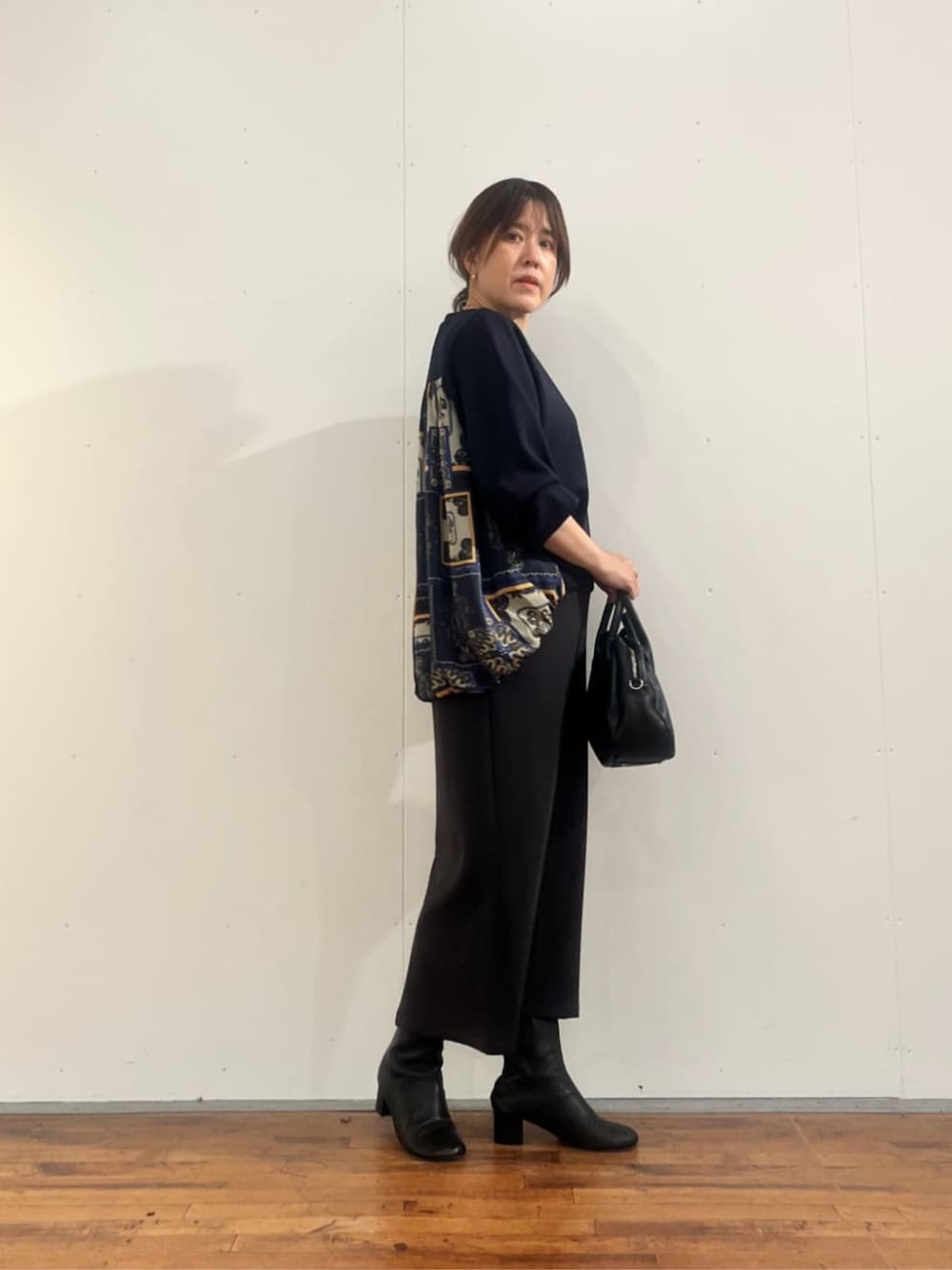 グレー系のスカート、ブラック系のトートバッグ、ブルー系のTシャツ/カットソーを着用したレディースの夏コーディネートの1枚目の写真