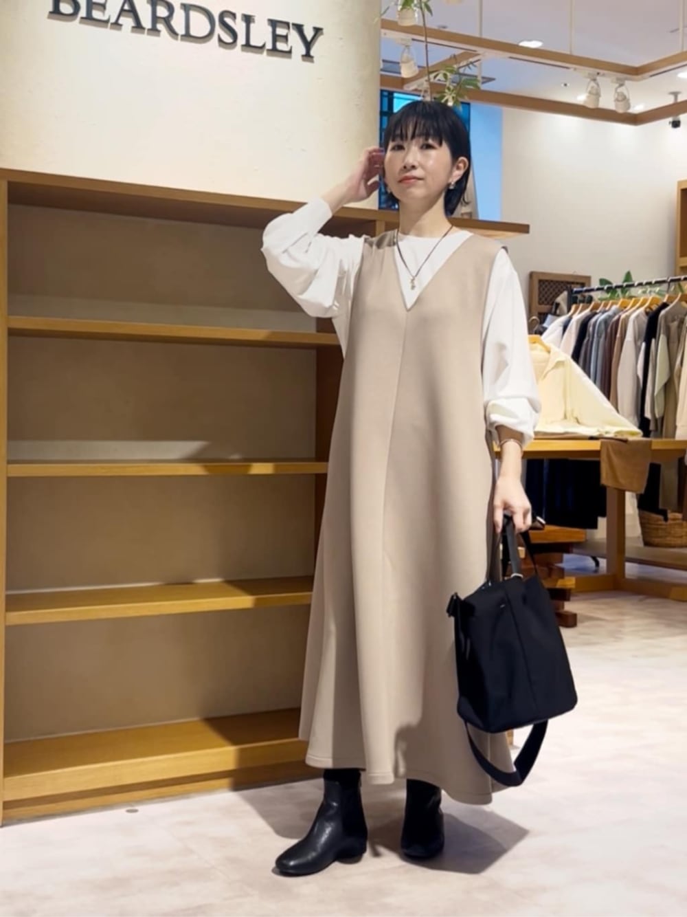 ブラック系のトートバッグ、ホワイト系のシャツ/ブラウス、ブラック系のブーツを着用したレディースの冬コーディネートの1枚目の写真