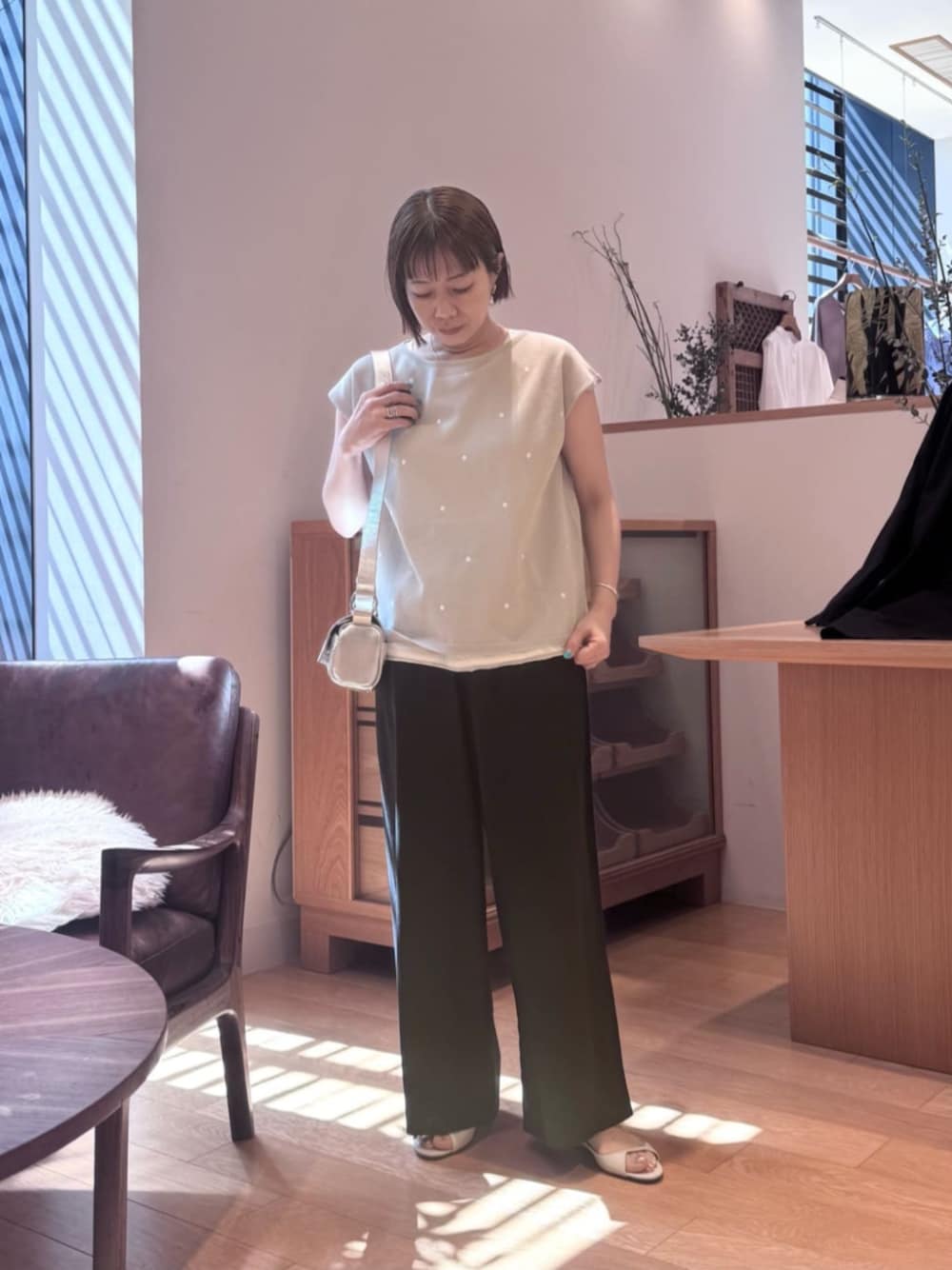 シルバー系のショルダーバッグ、ブラック系のその他パンツ、グレー系のニット/セーターを着用したレディースの春コーディネートの1枚目の写真