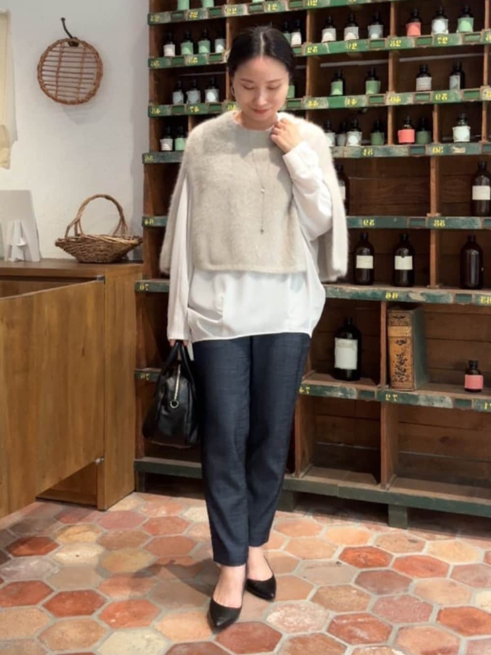 グレー系のニット/セーター、ブラック系のボストンバッグ、ブルー系のその他パンツを着用したレディースの秋コーディネートの1枚目の写真