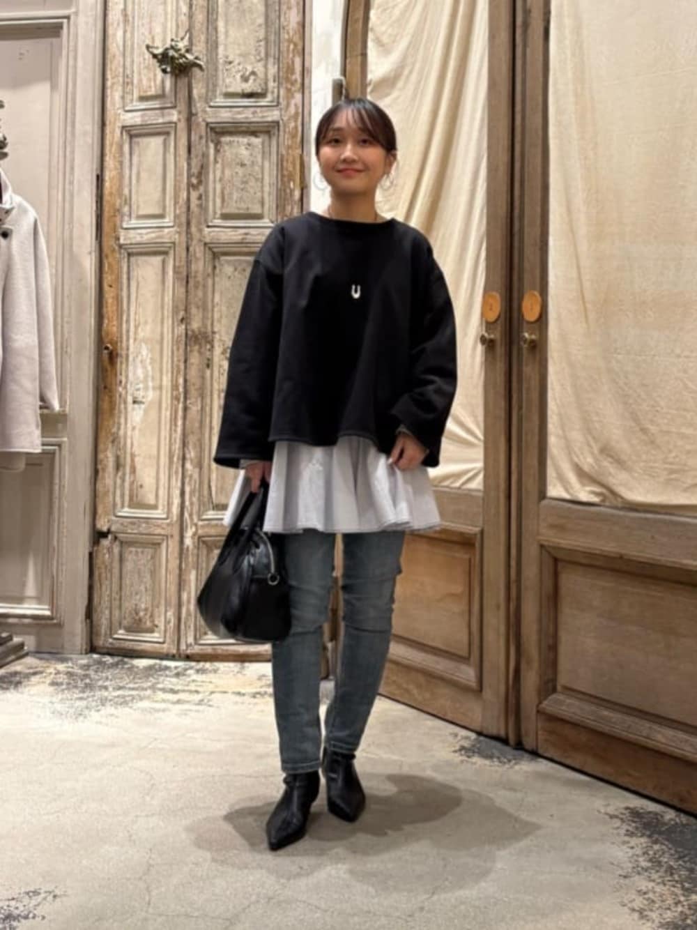 ブルー系のデニムパンツ、ブラック系のTシャツ/カットソーを着用したレディースの冬コーディネートの1枚目の写真