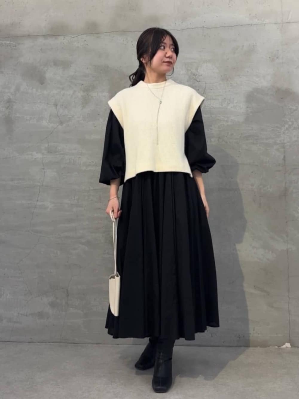 ブラック系のワンピース、ホワイト系のシャツ/ブラウス、ホワイト系のショルダーバッグを着用したレディースの冬コーディネートの1枚目の写真