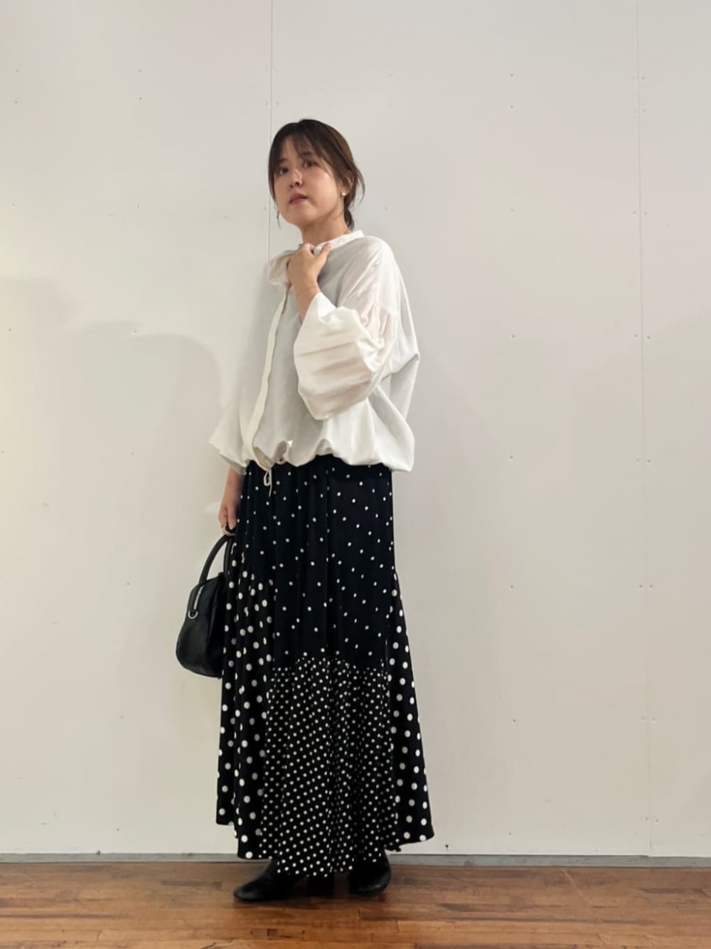 ブラック系のスカート、ホワイト系のシャツ/ブラウスを着用したレディースの夏コーディネートの1枚目の写真