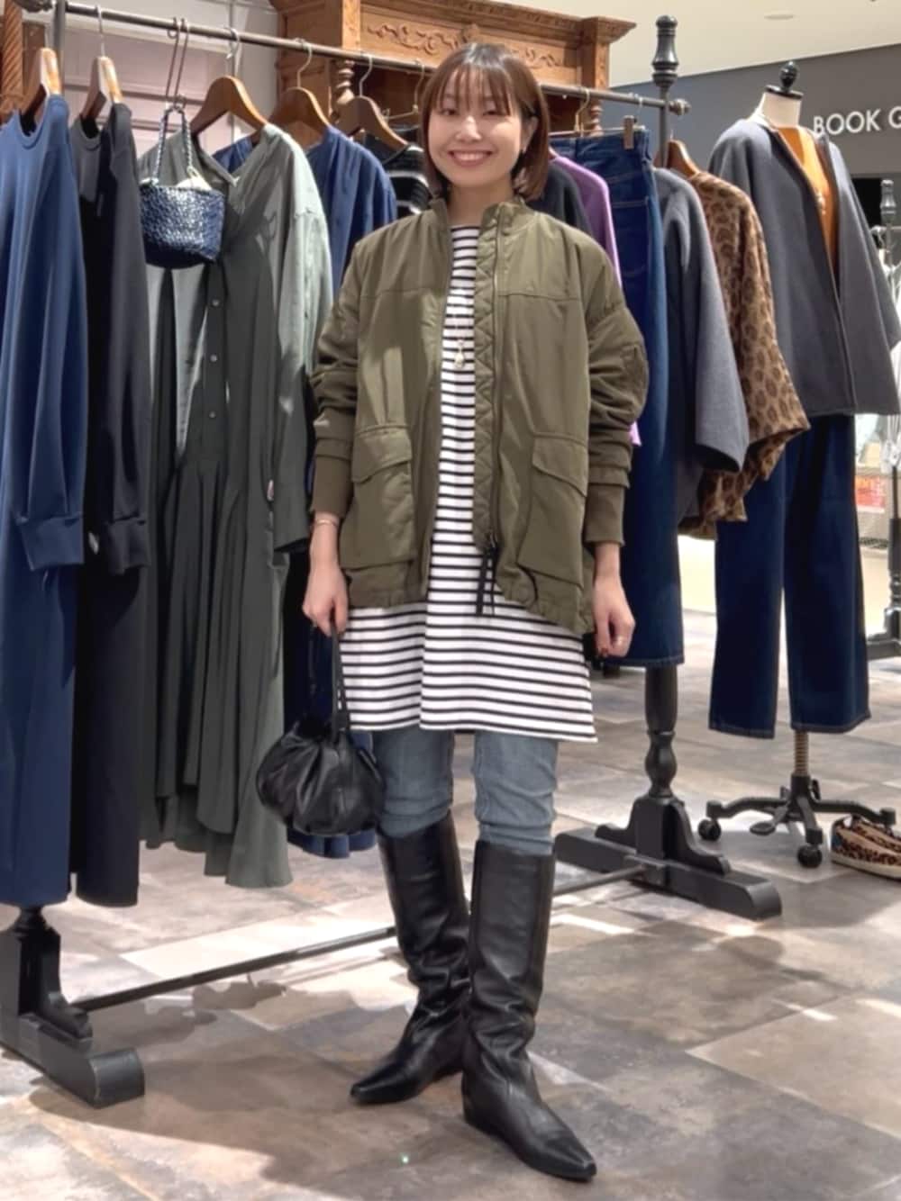 ブルー系のデニムパンツ、グリーン系のMA-1、ブルー系のTシャツ/カットソーを着用したレディースの秋コーディネートの1枚目の写真