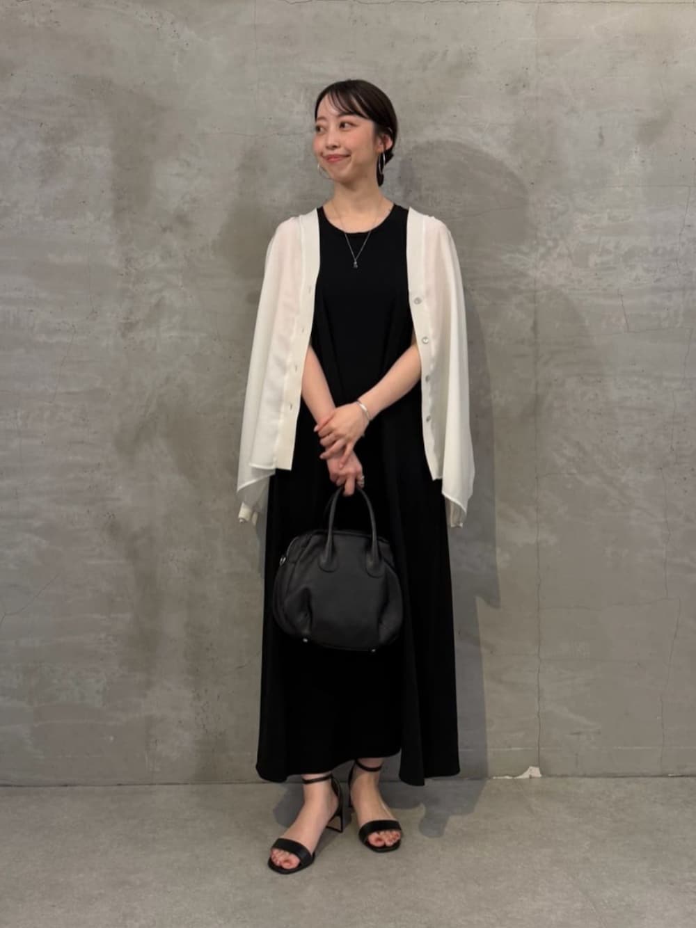ブラック系のボストンバッグ、ホワイト系のシャツ/ブラウス、ブラック系のワンピースを着用したレディースの春コーディネートの1枚目の写真