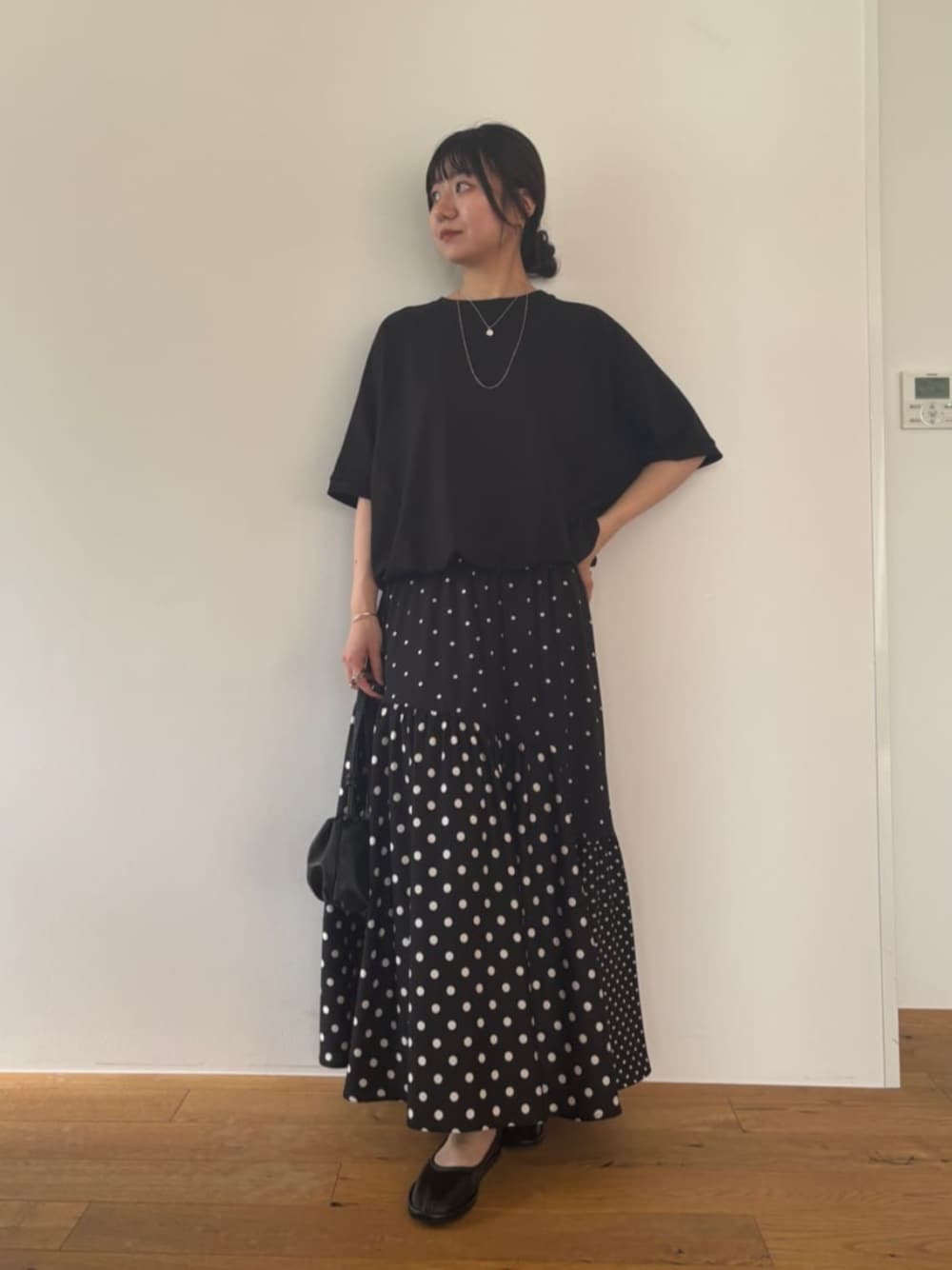 ブラック系のスカート、ブラック系のTシャツ/カットソーを着用したレディースの夏コーディネートの1枚目の写真